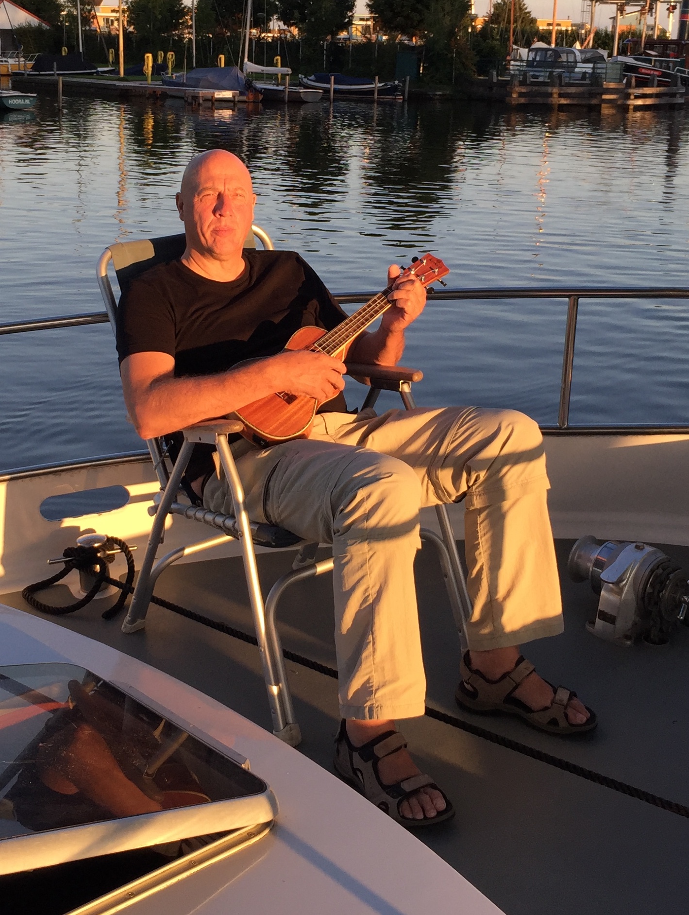 Detlev Alaze spielt Ukulele auf dem Boot bei Sonnenuntergang